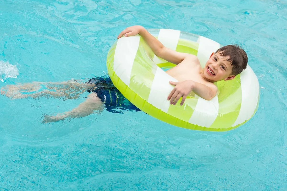 A child relaxing on a float in Hotel Lulu’s outdoor pool